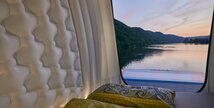 View of the forest and lake from the open sleeping area of the HYMER VisionVenture, which is a loft above the Mercedes motorhome. 